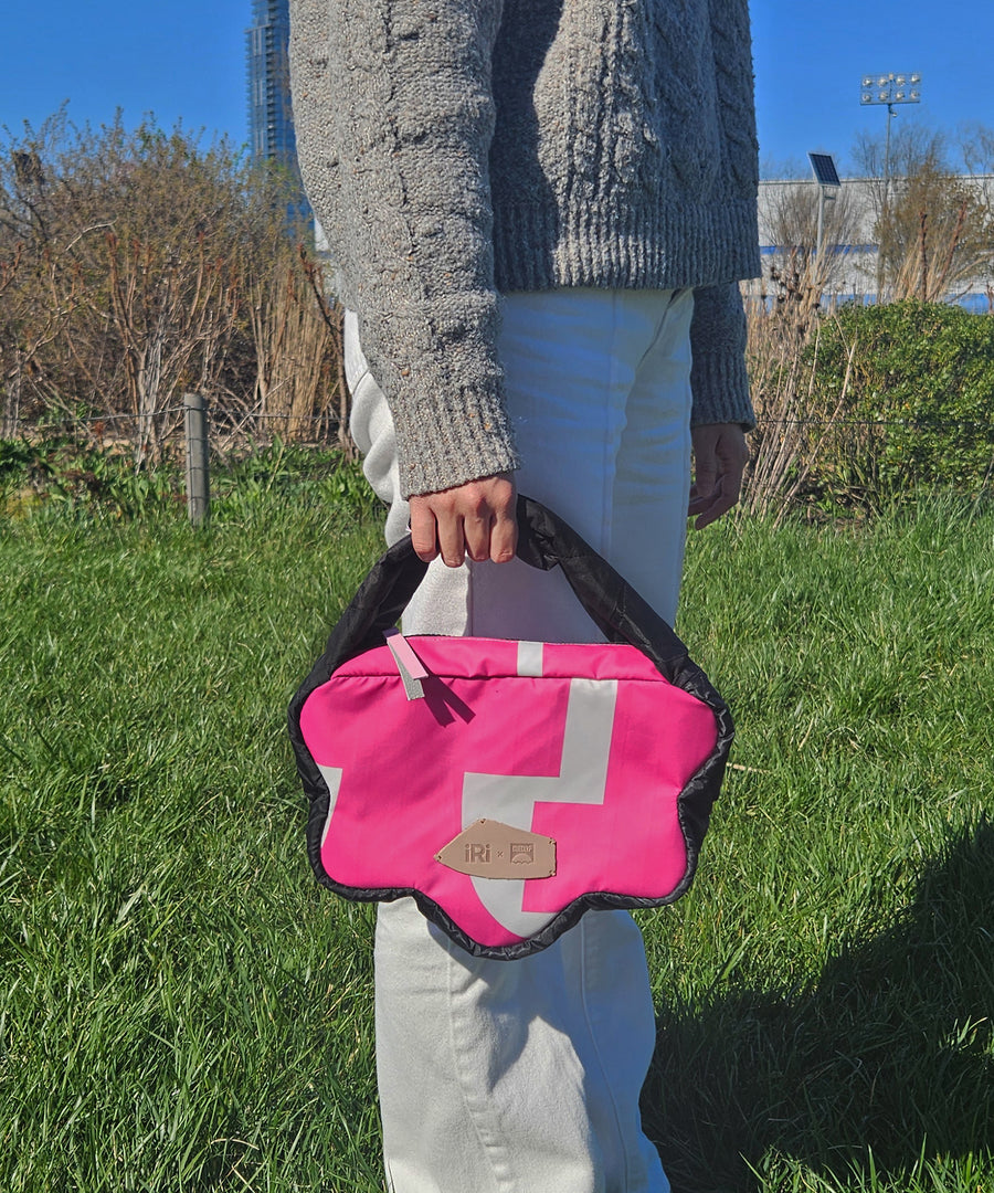 iRi Pink Hoorai Hobo Bag held by a model in a park