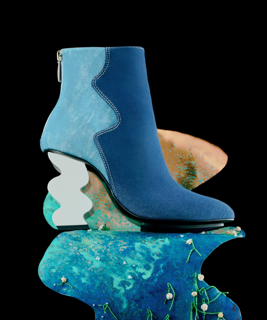Blue recycled denim INES ankle boot on a decorative platform with a black background