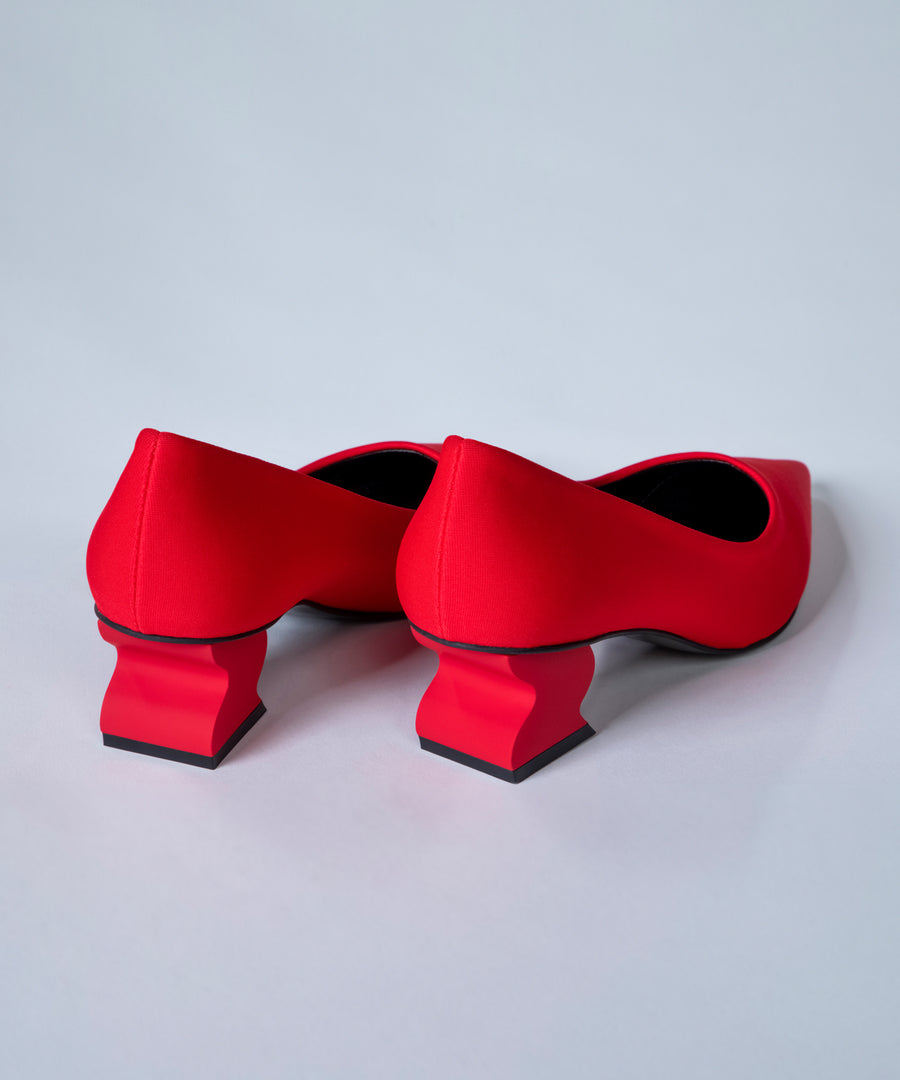 Red shoes with black soles on a light gray background